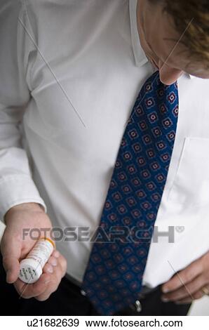 Man looking at prescription bottle View Large Photo Image Stock Photo - Man looking at prescription bottle. Fotosearch