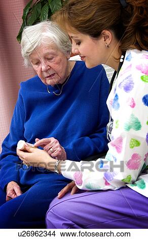 Nurse giving senior woman a bottle of pills View Large Photo Image Picture - Nurse giving senior woman a bottle of pills. Fotosearch