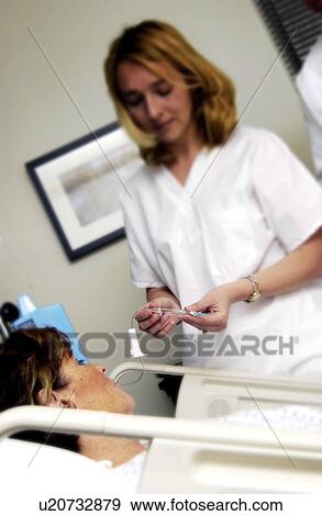 Stock Photo - Nurse setting up an IV. Fotosearch