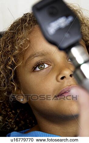 Stock Image - African American girl getting eye exam. Fotosearch