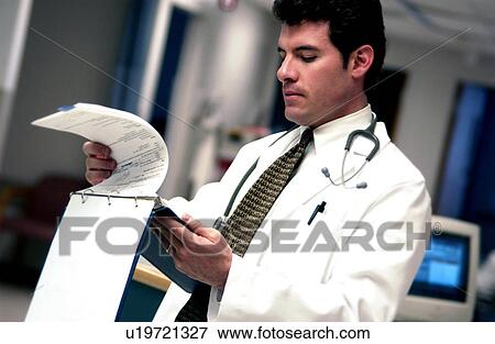 Doctor looking at patient chart View Large Photo Image Stock Photo - Doctor looking at patient chart. Fotosearch