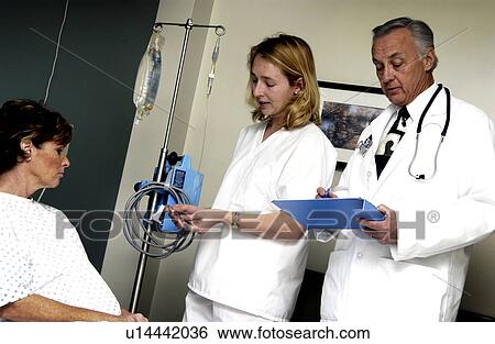 Doctor looking at patient chart View Large Photo Image Stock Photograph - Doctor looking at patient chart. Fotosearch