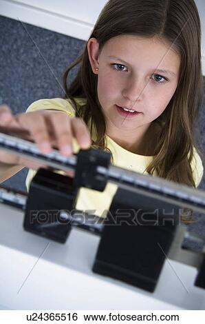 Stock Photograph - Girl on scale. Fotosearch
