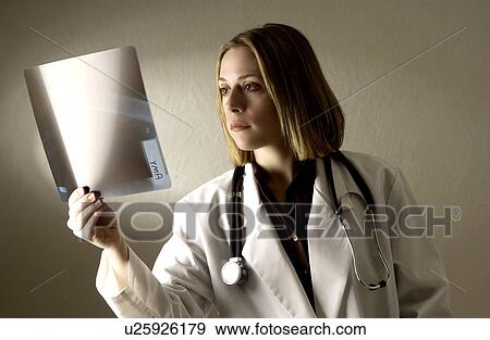 Physician looking at xrays View Large Photo Image Stock Photo - Physician looking at xrays. Fotosearch