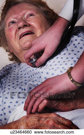 Stock Image - Senior woman sick in bed. Fotosearch
