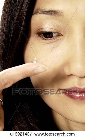 Stock Photo - Woman putting in contacts. Fotosearch