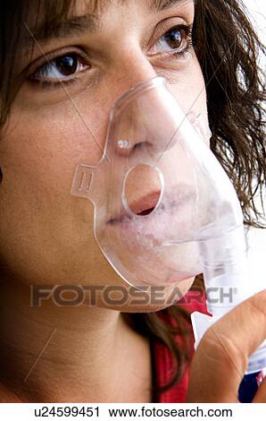 Stock Image - Woman using breathing machine. Fotosearch