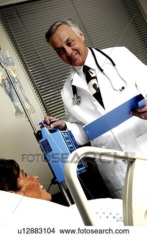 Picture - Doctor looking at patient chart . Fotosearch