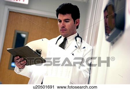 Doctor looking at patient chart View Large Photo Image Stock Image - Doctor looking at patient chart. Fotosearch