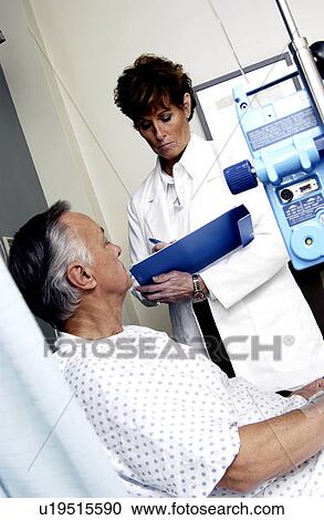 Stock Image - Doctor talking with patient. Fotosearch