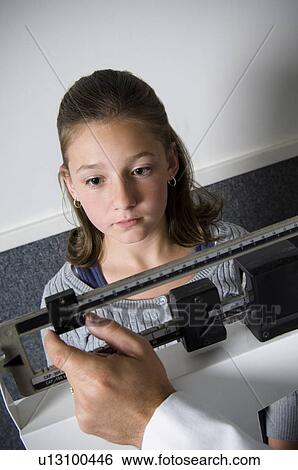 Stock Photograph - Girl on scale. Fotosearch