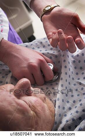 Stock Image - Nurse giving senior woman a checkup. Fotosearch