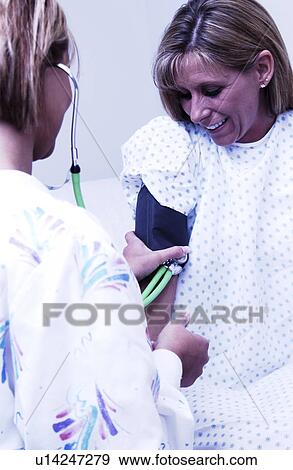 Nurse taking patients blood pressure View Large Photo Image Stock Photo - Nurse taking patients blood pressure. Fotosearch