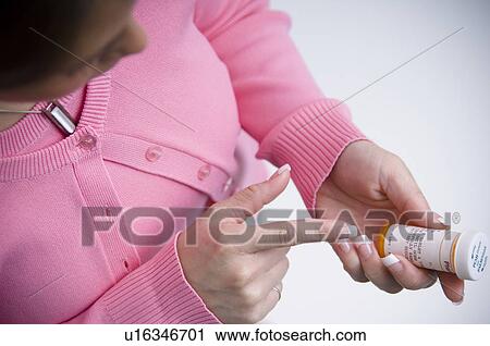 Woman looking at prescription bottle View Large Photo Image Stock Image - Woman looking at prescription bottle. Fotosearch