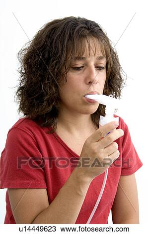 Stock Image - Woman using breathing machine. Fotosearch