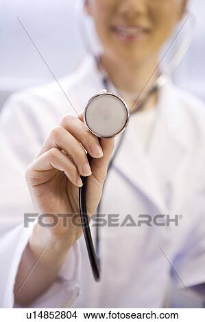 Picture - A female doctor examining patient with stethoscope. Fotosearch