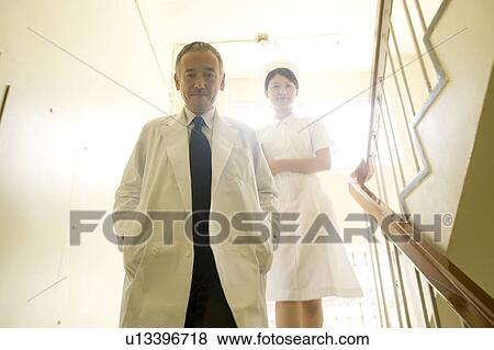 Doctor and female nurse descending staircases View Large Photo Image Stock Photo - Doctor and female nurse descending staircases. Fotosearch