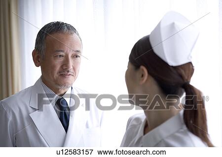 Stock Photo - Doctor and nurse talking. Fotosearch