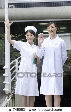 Stock Image - Doctor and nurse waving hands. Fotosearch