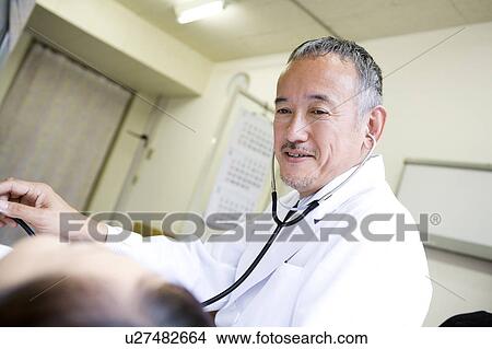 Picture - Doctor examining a patient. Fotosearch