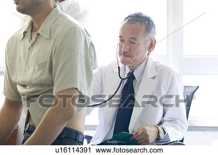 Doctor examining patient with stethoscope View Large Photo Image Stock Image - Doctor examining patient with stethoscope. Fotosearch