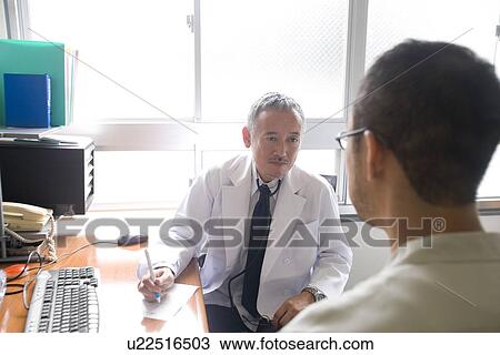 Stock Image - Doctor talking to patient. Fotosearch