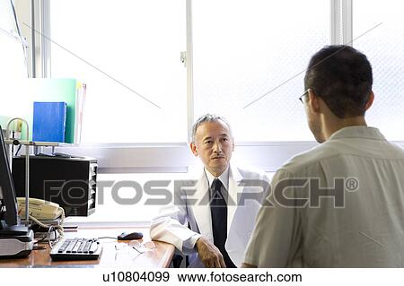 Stock Photo - Doctor talking to patient. Fotosearch
