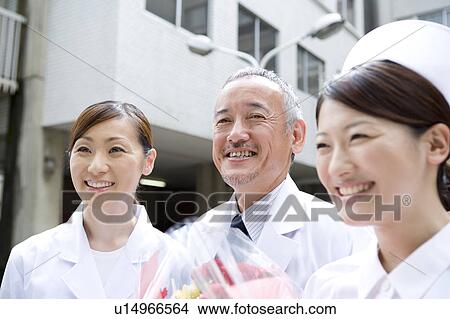 Doctors and nurse giving bunch of flowers View Large Photo Image Picture - Doctors and nurse giving bunch of flowers. Fotosearch