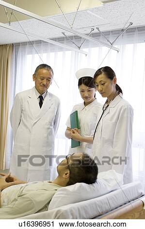 Doctors and nurse talking to patient in bed View Large Photo Image Stock Image - Doctors and nurse talking to patient in bed. Fotosearch
