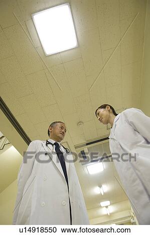 Doctors talking at corridor View Large Photo Image Stock Image - Doctors talking at corridor. Fotosearch