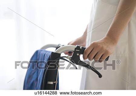 Hand of female nurse pushing wheelchair View Large Photo Image Stock Photo - Hand of female nurse pushing wheelchair. Fotosearch