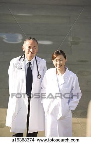 Two doctors standing View Large Photo Image Picture - Two doctors standing. Fotosearch