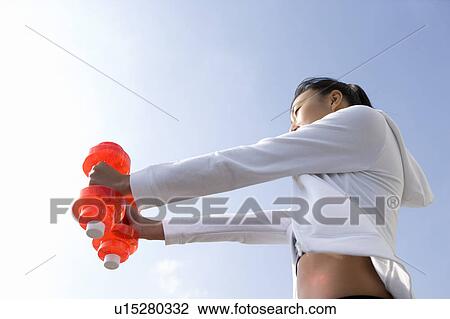 Woman exercising with dumbbells View Large Photo Image Stock Image - Woman exercising with dumbbells. Fotosearch