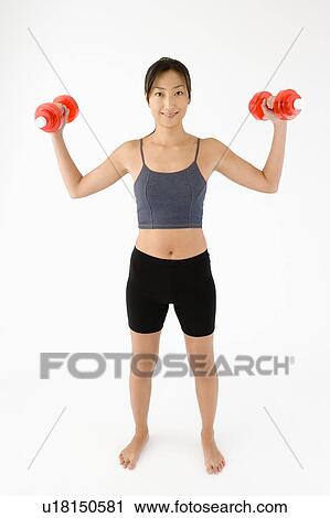 Woman exercising with dumbbells View Large Photo Image Stock Image - Woman exercising with dumbbells. Fotosearch