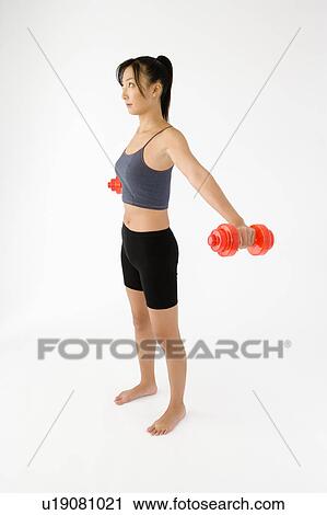 Stock Image - Woman exercising with dumbbells. Fotosearch