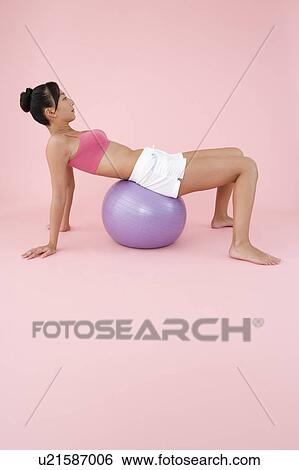 Stock Photograph - Woman exercising with fitness ball. Fotosearch