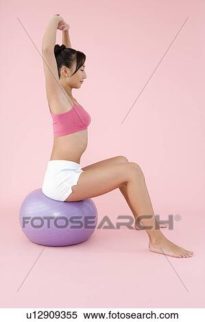 Stock Photography - Woman exercising with fitness ball. Fotosearch
