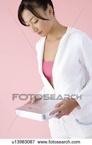 Woman holding bathroom scale View Large Photo Image Stock Photo - Woman holding bathroom scale. Fotosearch