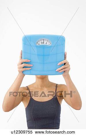Stock Photography - Woman holding bathroom scale. Fotosearch