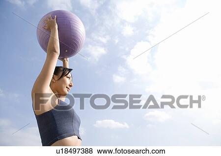 Stock Photo - Woman holding fitness ball. Fotosearch