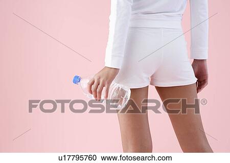 Woman holding water bottle, midsection, rear view View Large Photo Image Stock Image - Woman holding water bottle, midsection, rear view. Fotosearch