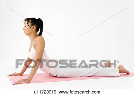 Stock Photo - Woman lying on floor stretching. Fotosearch