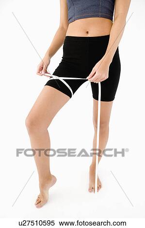 Stock Photography - Woman measuring her thigh. Fotosearch