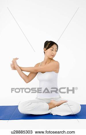 Woman sitting on floor stretching View Large Photo Image Stock Image - Woman sitting on floor stretching. Fotosearch