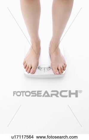 Woman standing on bathroom scale View Large Photo Image Picture - Woman standing on bathroom scale. Fotosearch
