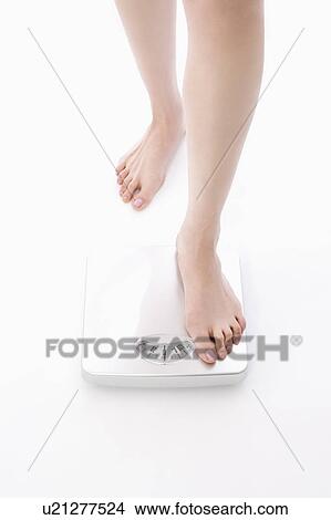 Woman stepping on bathroom scale View Large Photo Image Picture - Woman stepping on bathroom scale. Fotosearch