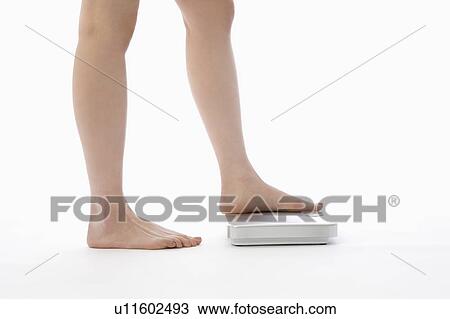 Woman stepping on bathroom scale View Large Photo Image Stock Image - Woman stepping on bathroom scale. Fotosearch