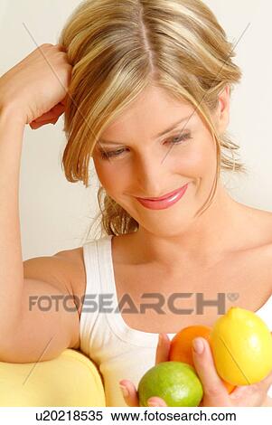 Stock Photography - Woman holding citrus fruit. Fotosearch