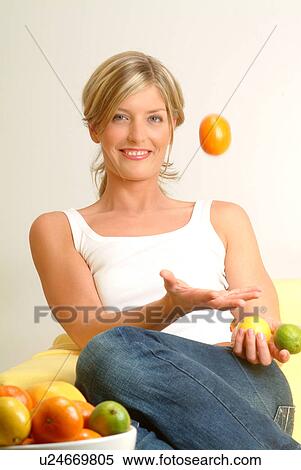 Stock Photography - Woman tossing orange. Fotosearch