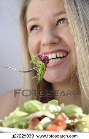 Young blond woman eating salad, smiling View Large Photo Image Stock Photo - Young blond woman eating salad, smiling. Fotosearch